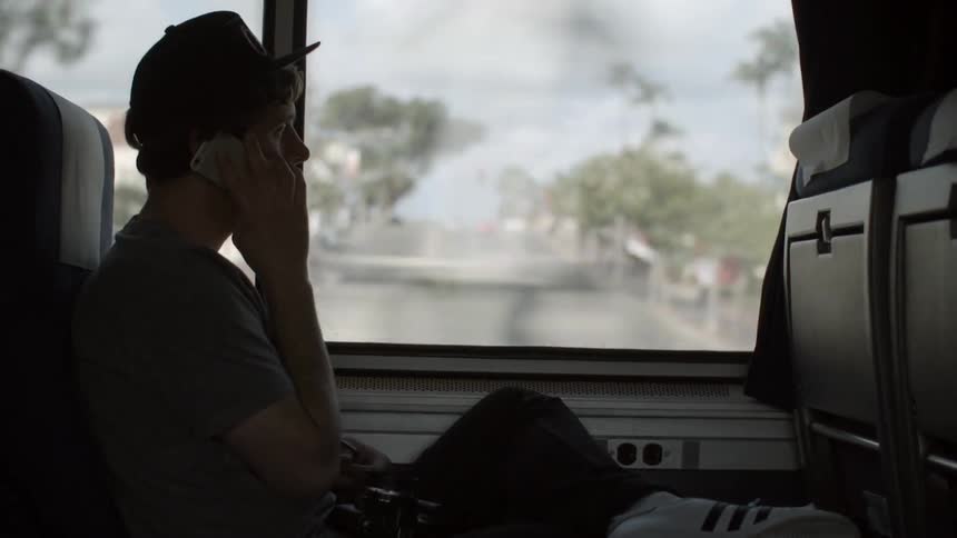 A man on a bus talks on his phone
