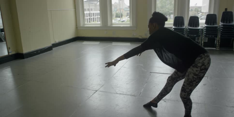 A woman is dancing in front of a mirror