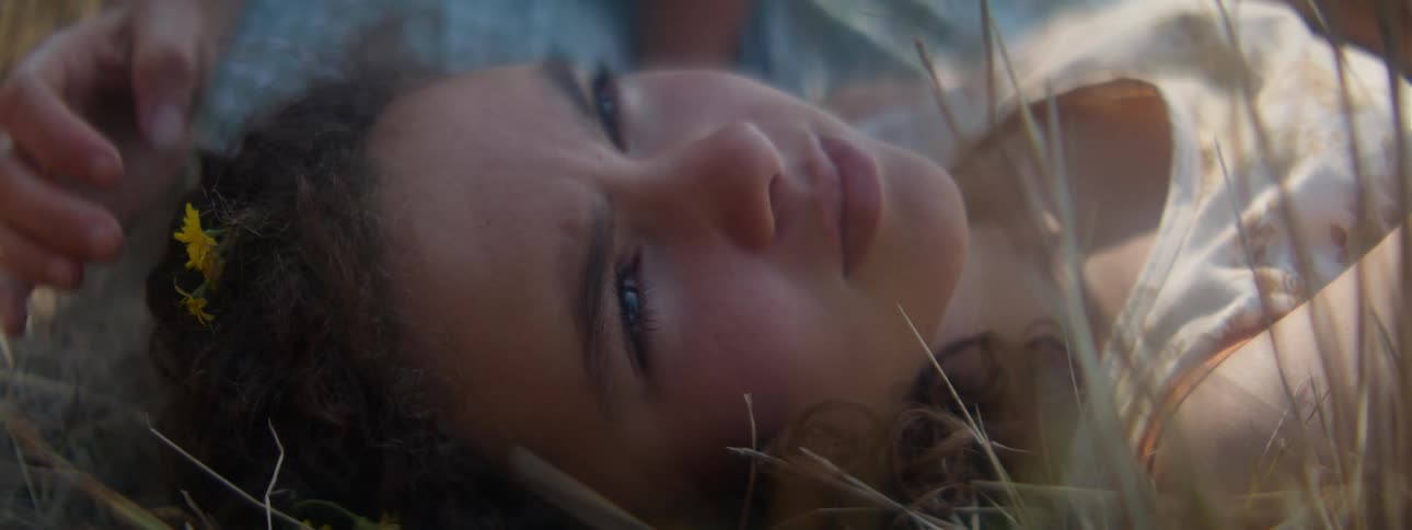 A woman laying around in the grass resting