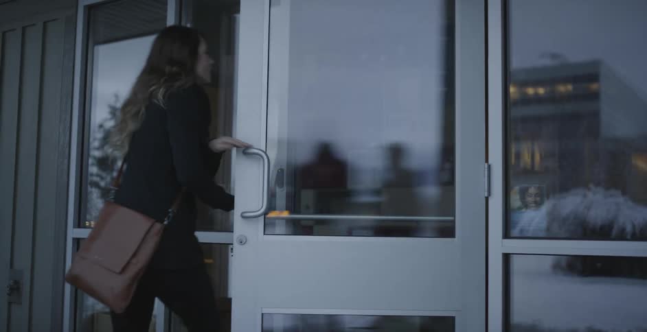 A female walking quickly into a building
