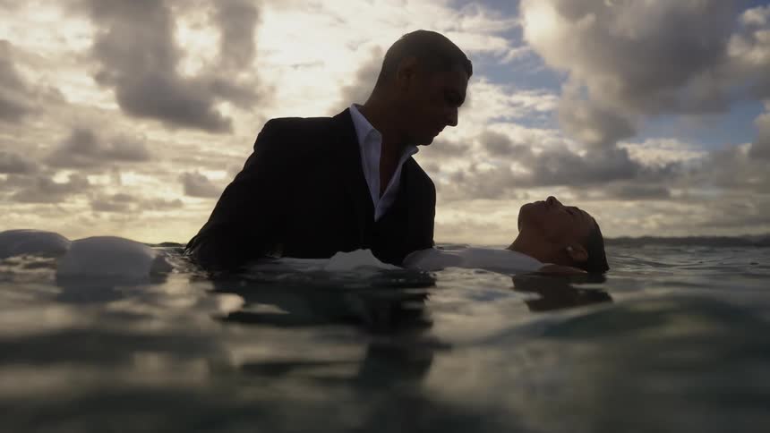 A man helps his partner float underwater