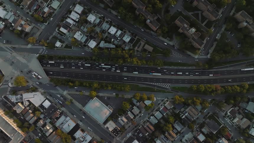 An aerial view of a backed up highway near buildings and houses