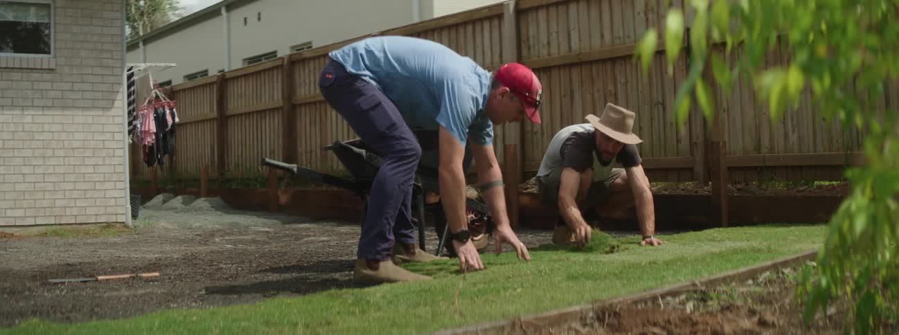 Two men are gardening in their back yard