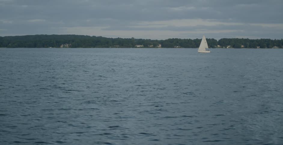 A sailboat on a lake on an overcast day