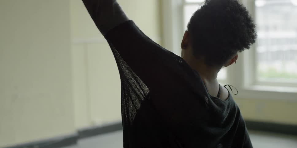 A woman dances in a bright studio