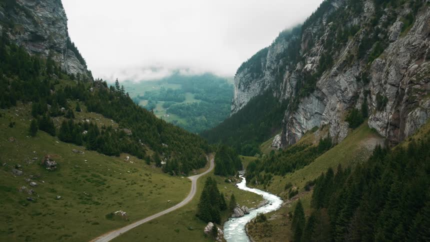 A stream and a road running through a mountain valley