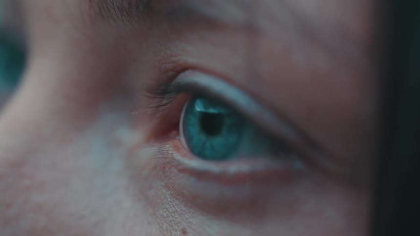 A young woman blinks while looking in the distance