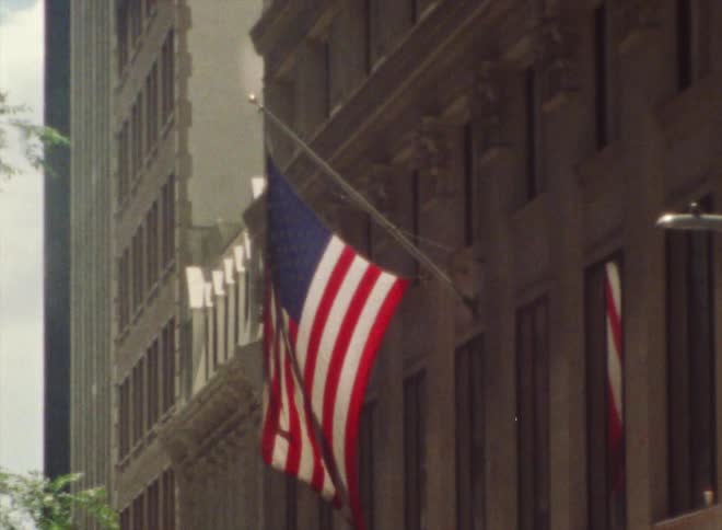 Exterior view of building with american flag and pole in the busy street