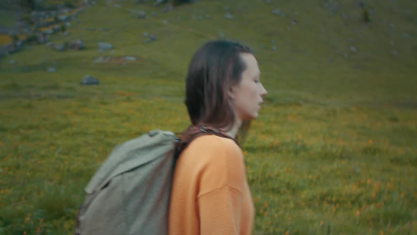 A backpacker hikes alone through a field