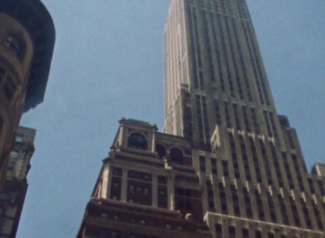 A view of a tall skyscraper in the city from the bottom up