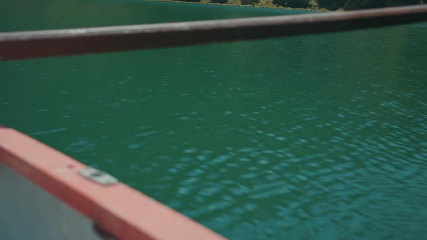 An up close view of a paddle going in and out of the water attached to the boat