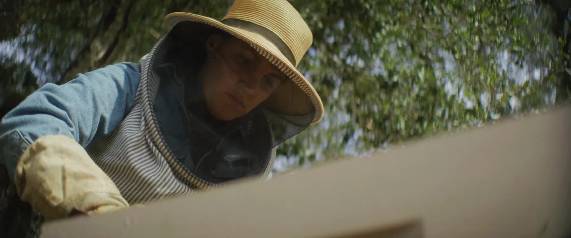 A beekeeper is checking on her harvest