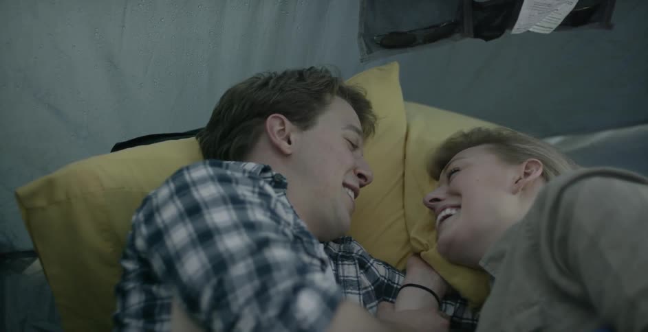 A man and woman lay facing each other and talking