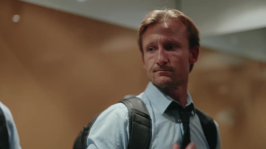 Man checks his appearance in mirror while waiting