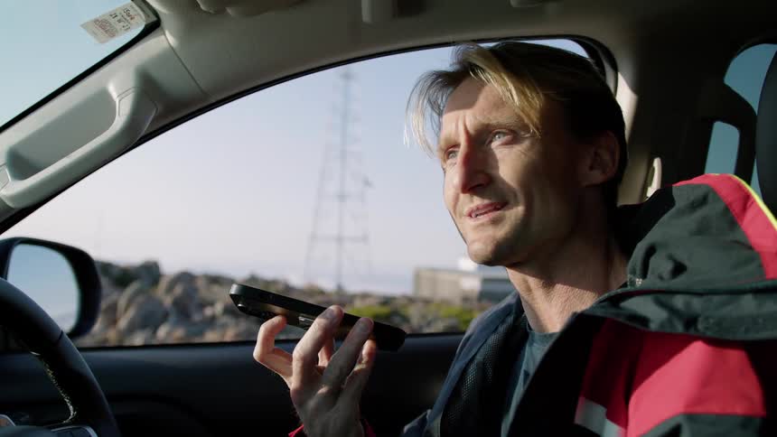 A man is talking on the phone in his car