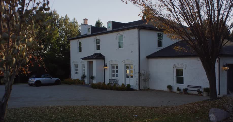 Exterior view of villa and gray sports car in the countryside