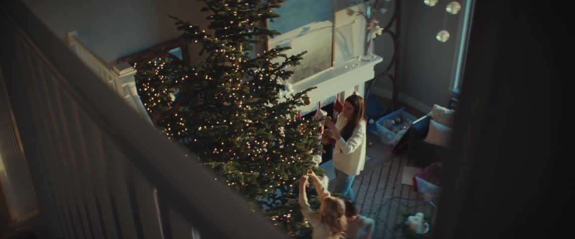 A family puts ornaments on their christmas tree