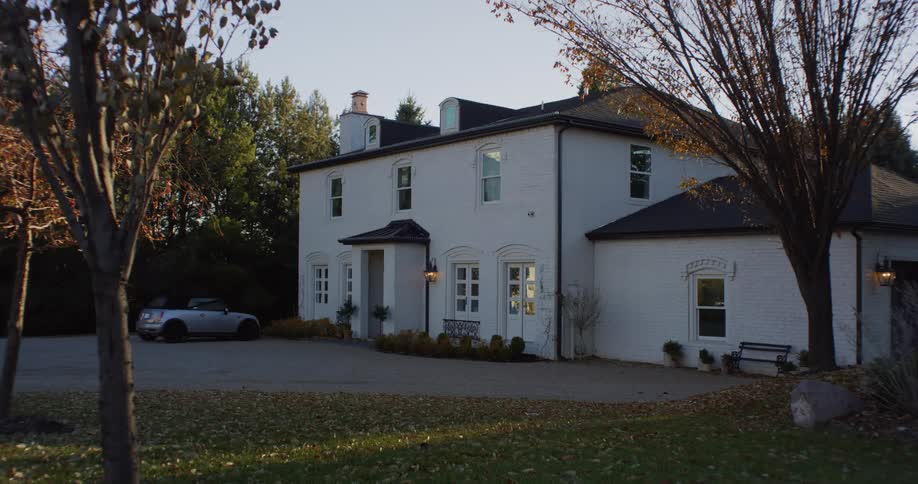 A car parked in front of a large home