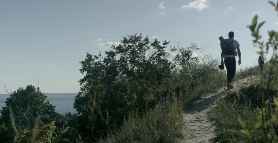 A man and two children walk up a small path