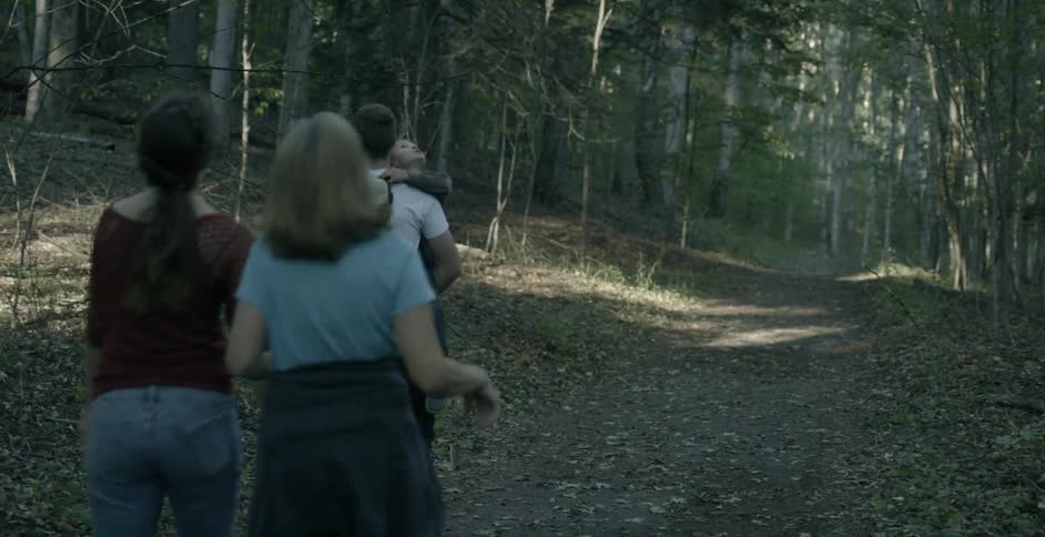 Three people and two children walk down a path