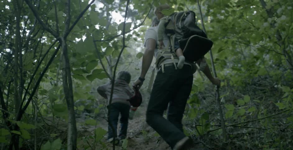 A man and two children hiking in the forest