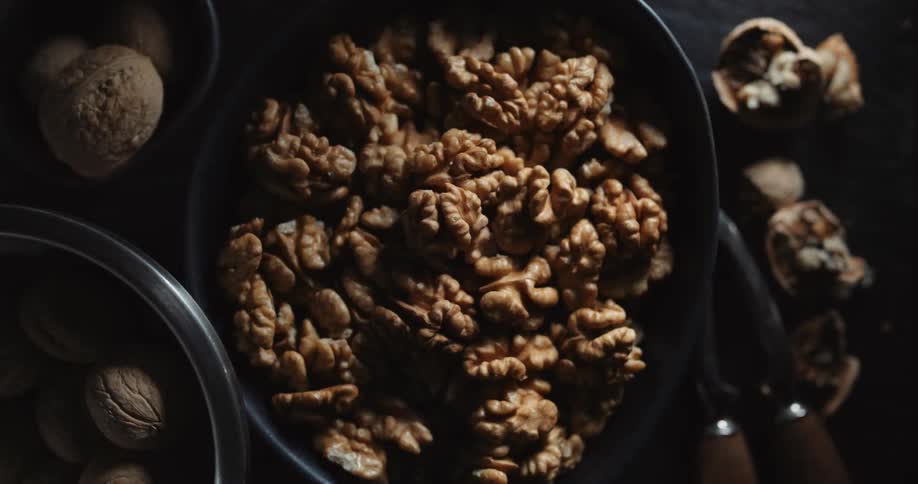 A bowl full of shelled walnuts on a table