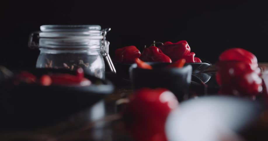 Chili peppers surround a mason jar filled with star anise pods