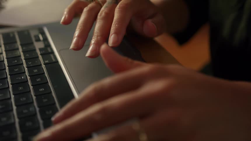 Close up of womans hand using touchpad on laptop