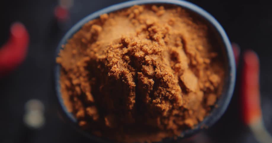 A bowl is filled with ground chili peppers