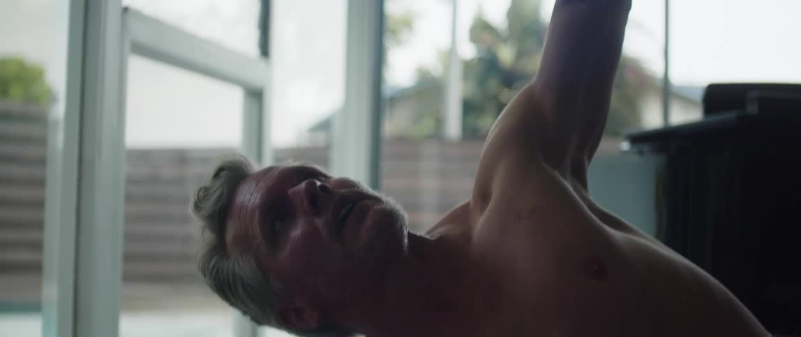Man moves through yoga pose near piano