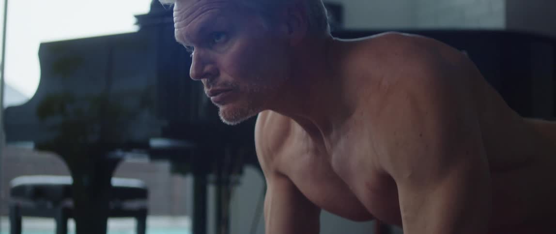 A man holds a push up while working out at home