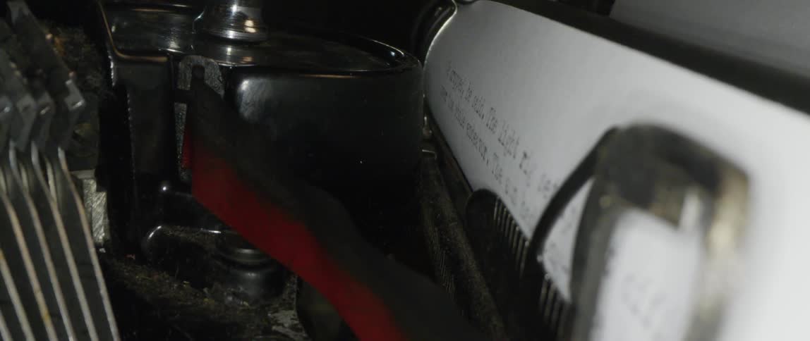 The keys of a vintage typewriter strike a paper