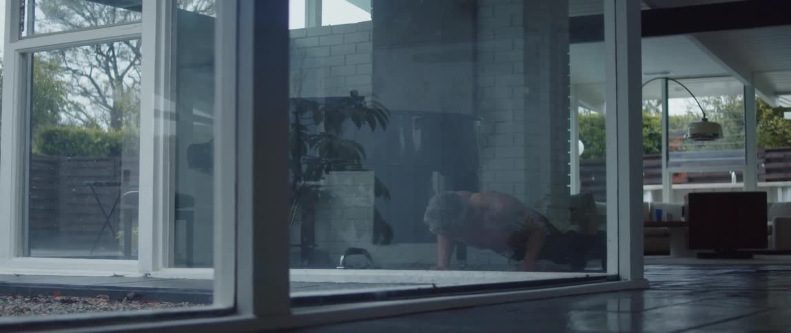 Muscular man does push up on yoga mat in room