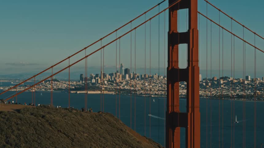 Tourists take photos of downtown San Francisco and the Golden Gate Bridge
