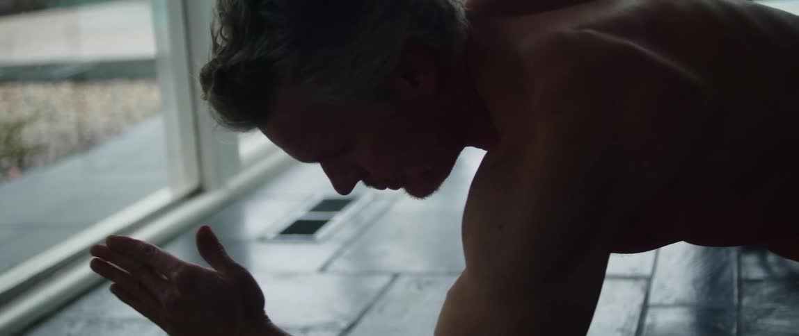A man is stretching and exercising indoors