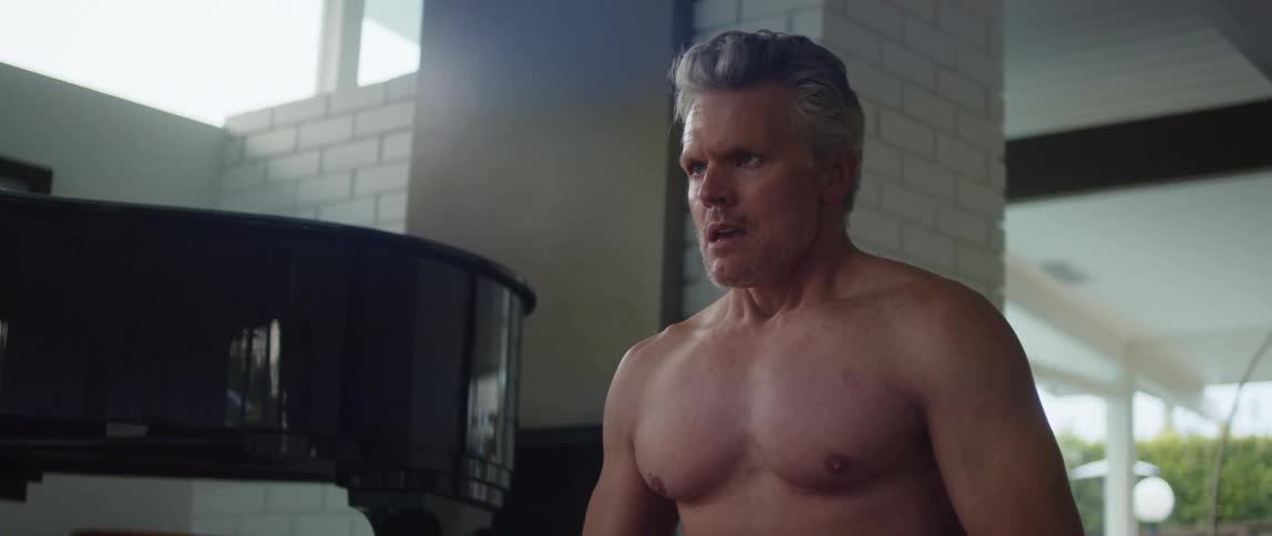 A shirtless man is taking deep breaths