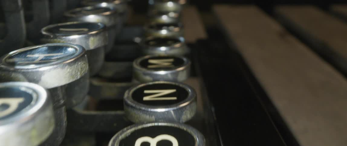 Manual typewriter with round keys sits on wooden slats