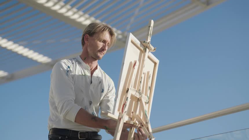 A man painting on an easel
