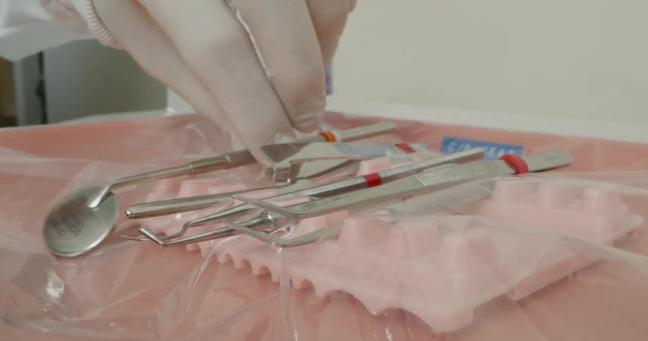 A technician in a dental clinic sets instruments out