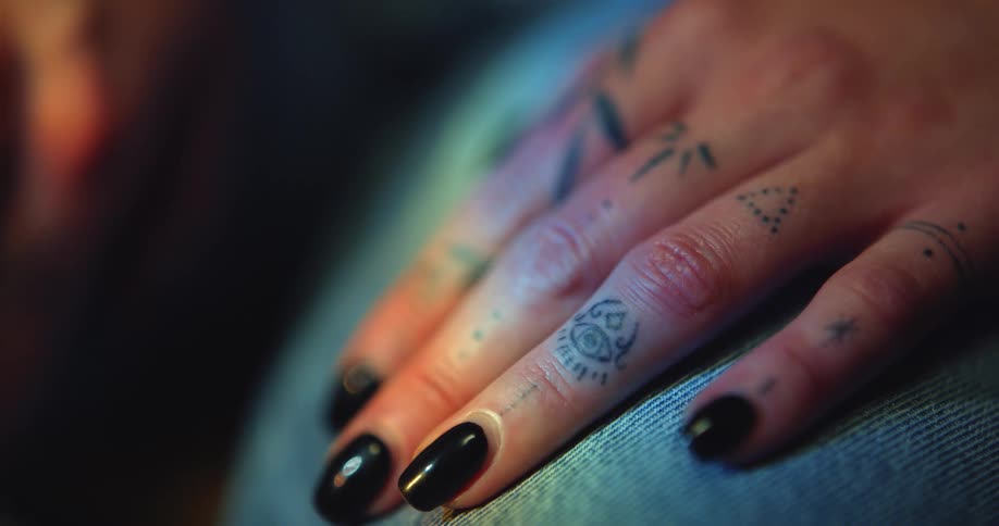 A females tattooed hand on her lap