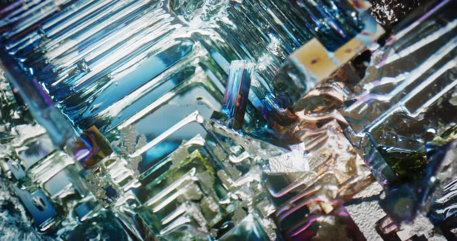 Light shines on the shiny reflective textured surface of an object with many dimensions and a blue highlight