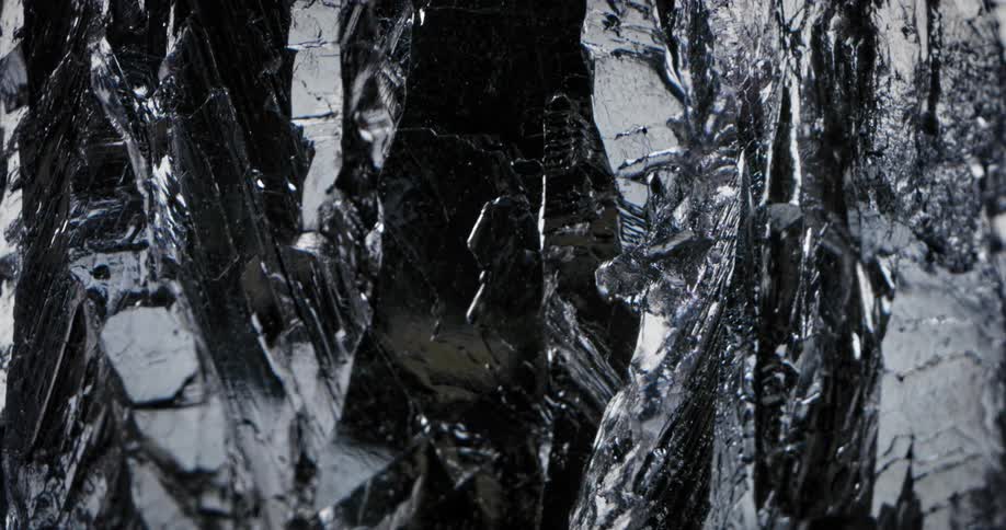 Light shines on a rock with a shiny silver reflective surface