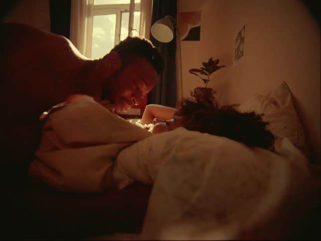 A man jumps into bed with a woman