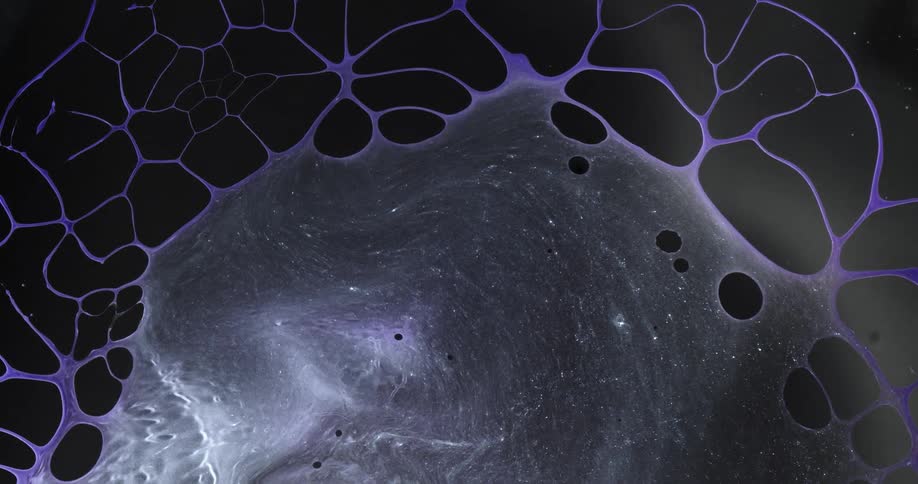A purple liquid is flowing out and drawing back creating a honeycomb pattern