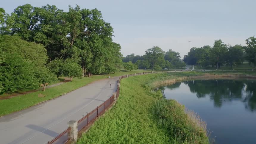 A person is traveling along a road by the lake