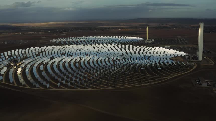 Aerial orbiting view of a solar farm in the arid countryside