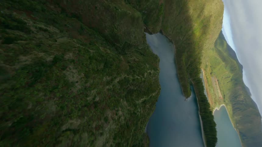 A calm lake sits in the center of a canyon covered in vegetation