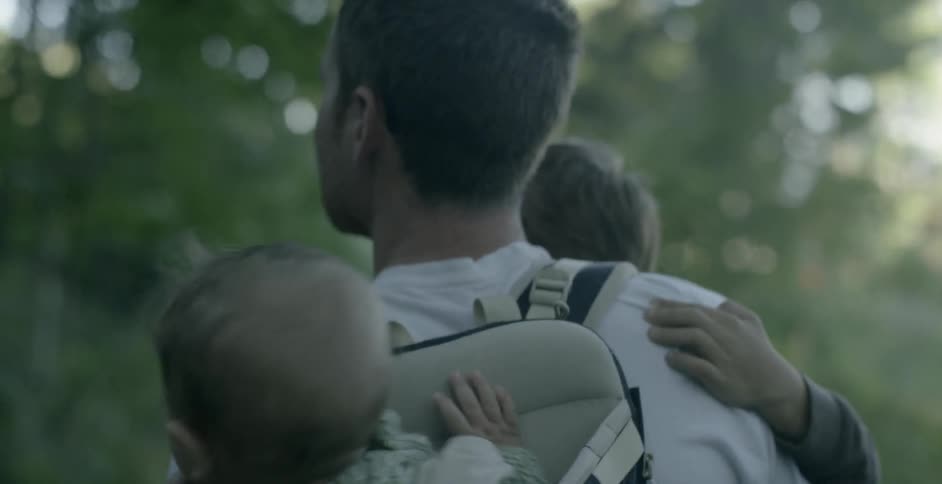 A man carries his children while on a hike