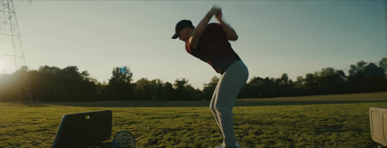 A man practices his golf swing