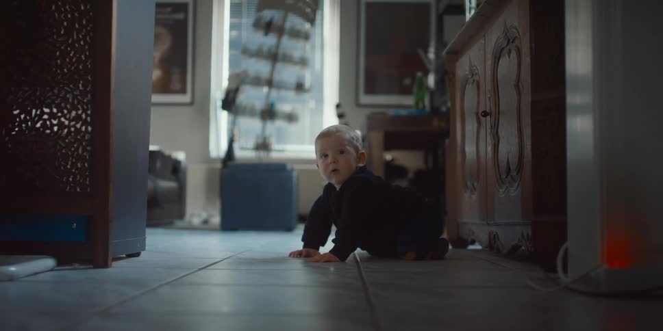 Crawling baby looks around room in home